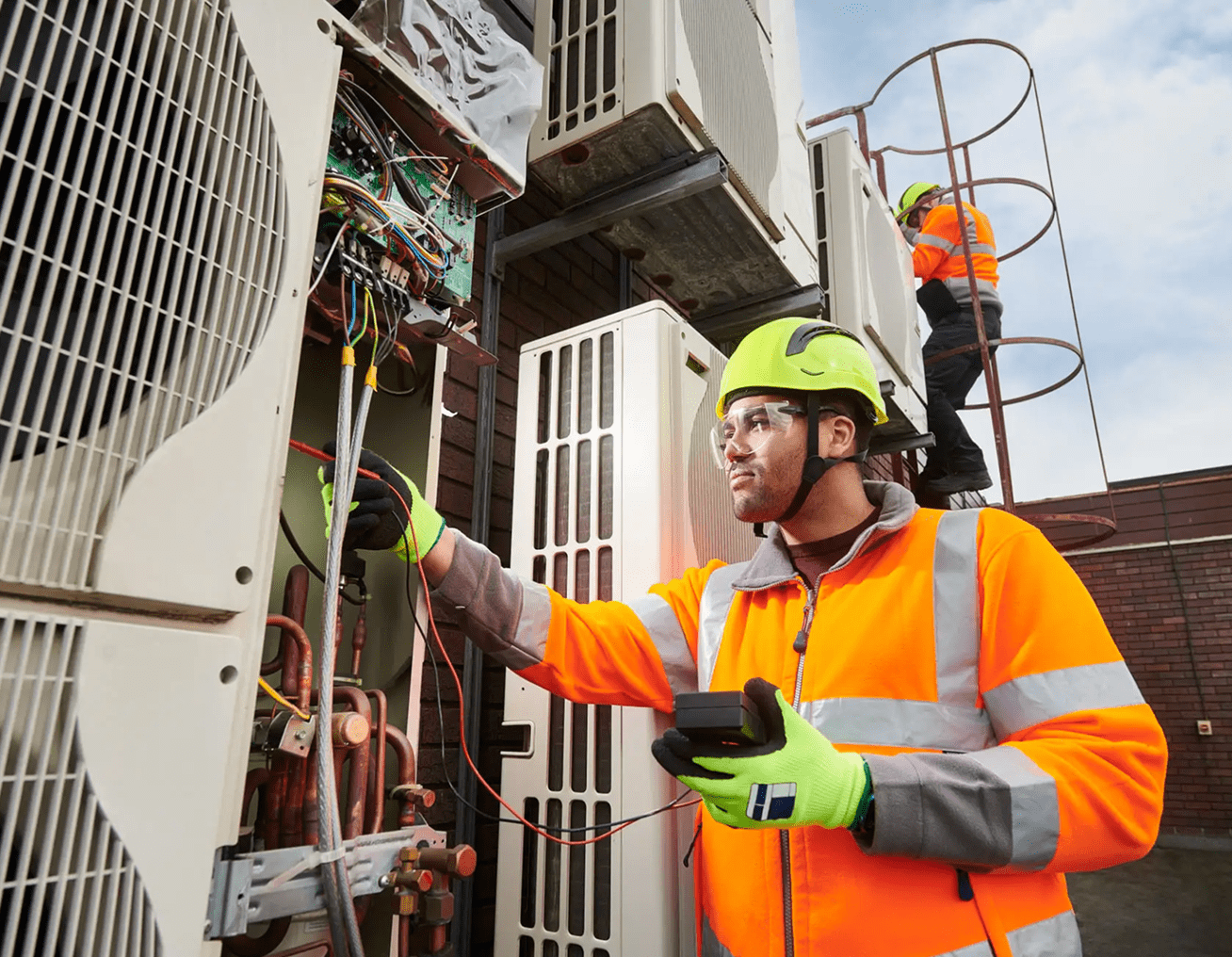 Technicians working on industrial air conditioning unit